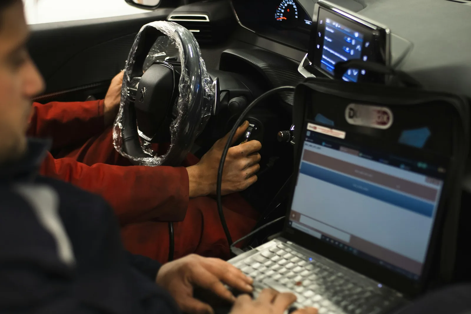 Mechanici připojují diagnostický notebook k autu