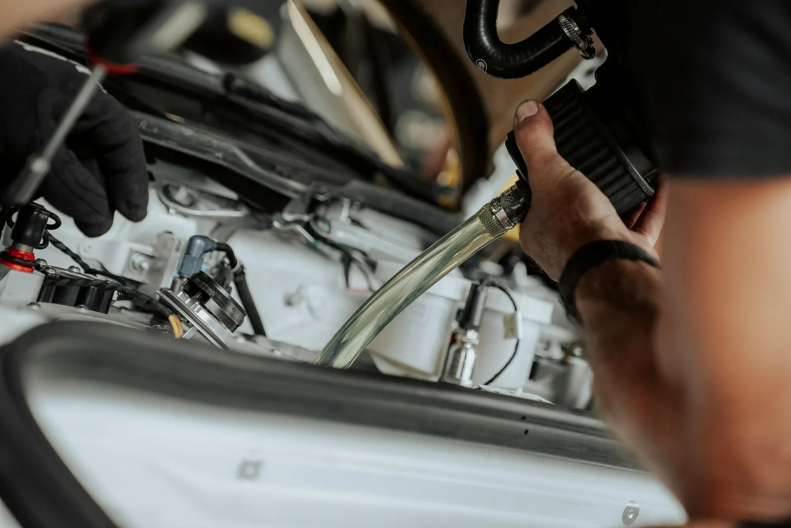 Mechanik doplňuje provozní kapaliny do motoru