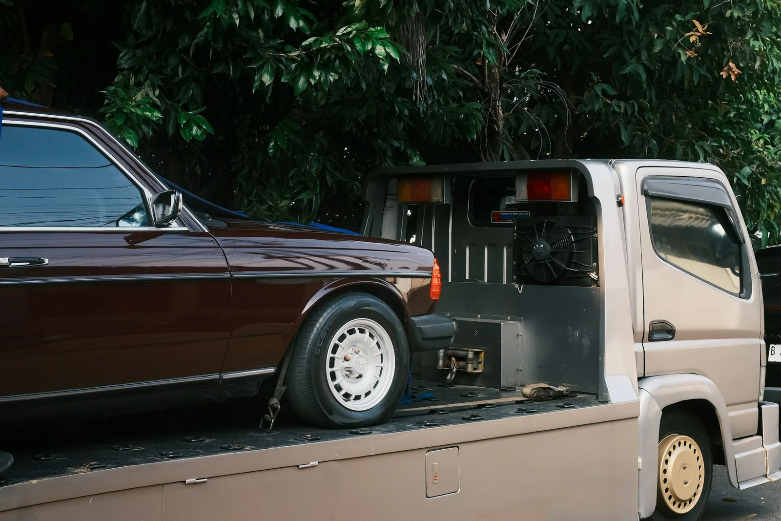 Osobní auto upevněné na korbě odtahového vozu