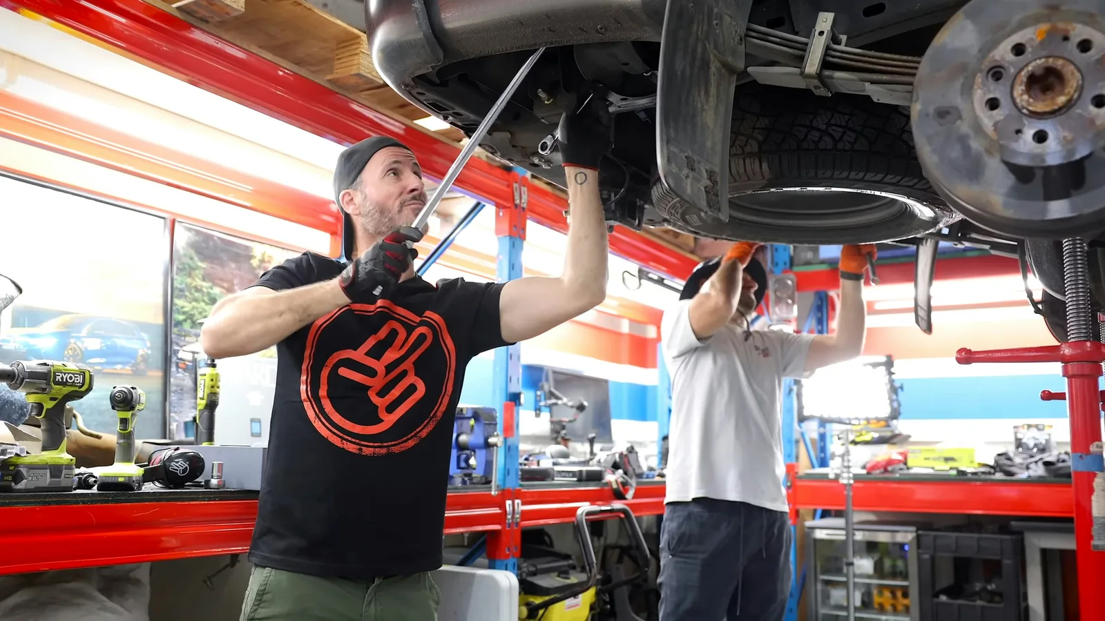 Mechanici opravují podvozek auta na zvedáku